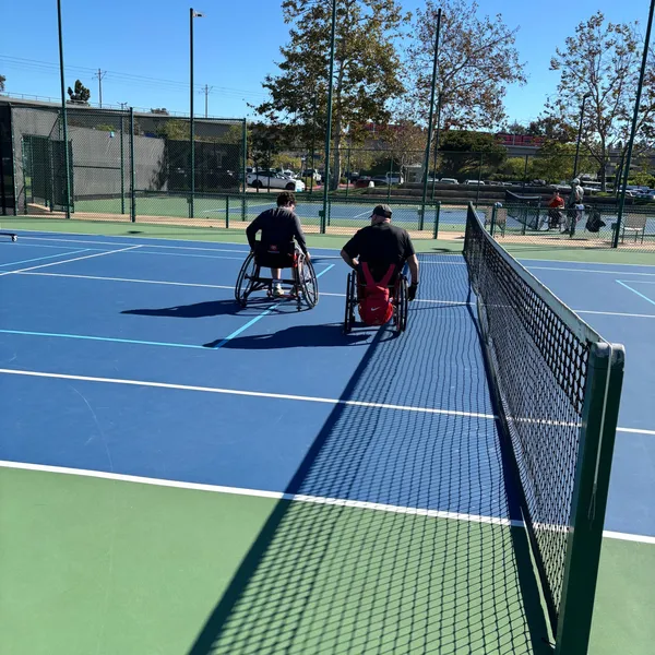 Two wheelchair players near the net during the session
